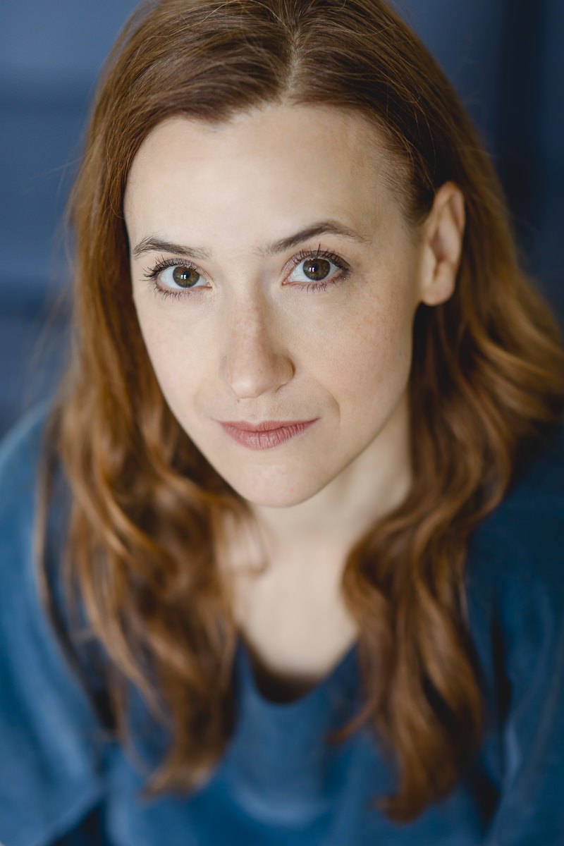 Headshot Portraitfoto einer Schauspielerin vor blauem Hintergrund | Foto: Hanna Witte
