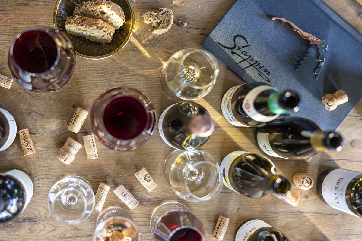 leere und gefüllte Weingläser, geöffnete Weinflaschen und Korken auf einem Tisch im Restaurant Stappen | Foto: Hanna Witte