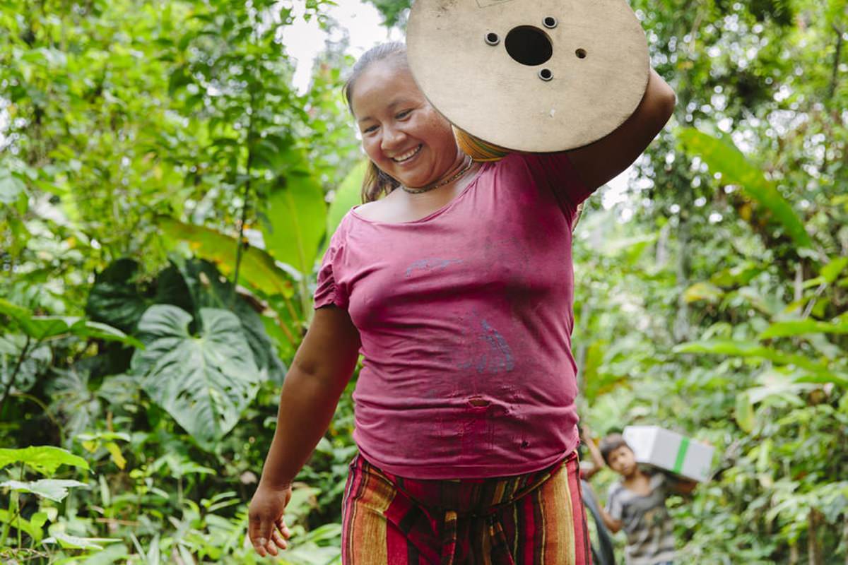 eine indigene Frau hilft beim Entladen einer Solar-Anlage für ihr Dorf in Ecuador | Foto von NGO Fotografin Hanna Witte