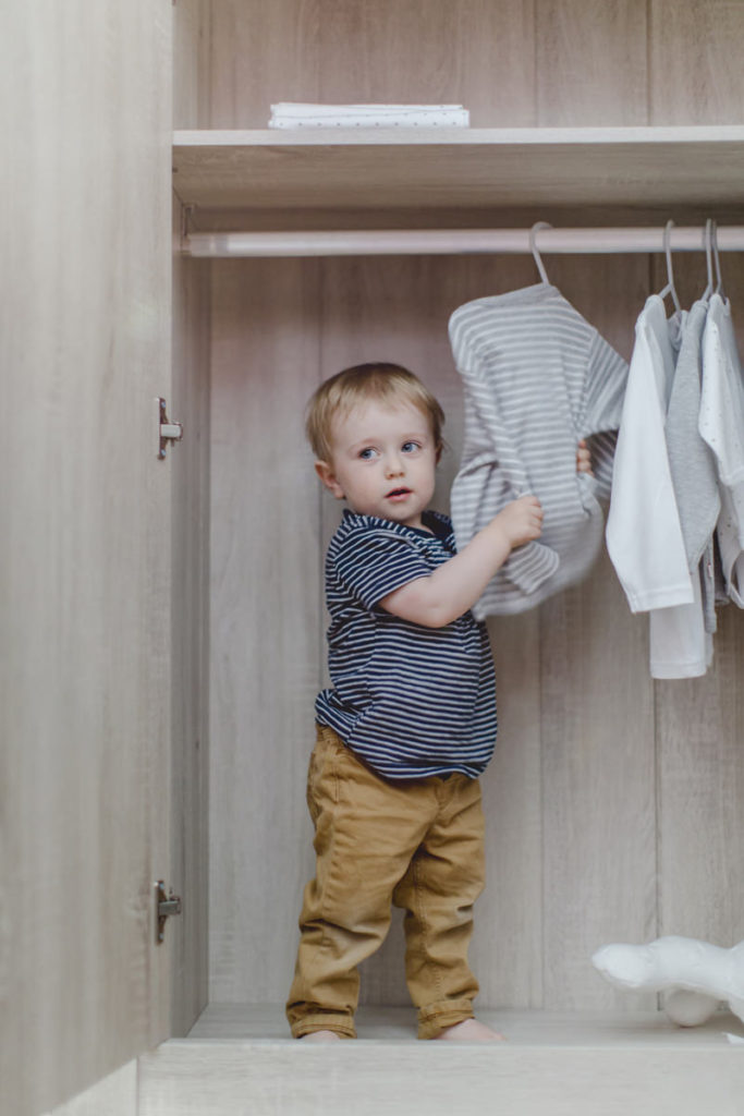 kleines Kind im Kleiderschrank