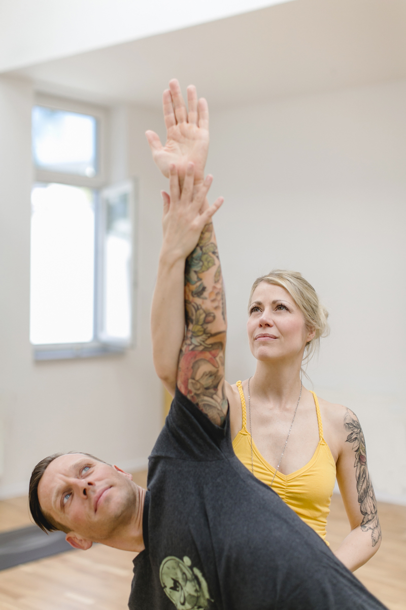 Yoga Lehrerin hilft ihrem Schüler bei einer Yoga Übung