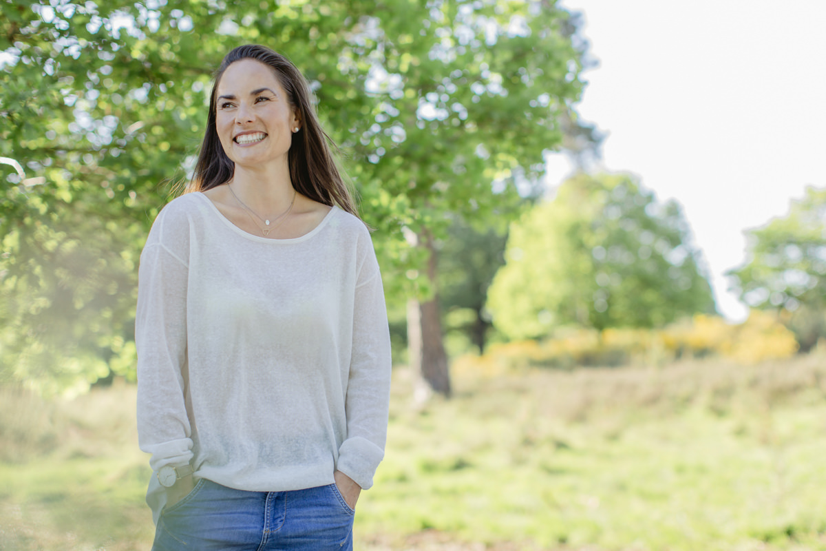 freundliches Portraitfoto eines weiblichen Meditations Coach in der Natur