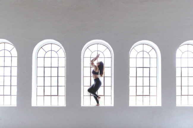 kreatives Portraitfoto einer Yoga Lehrerin vor einem Fenster