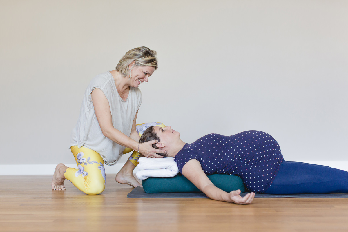 Yogafoto einer Yogalehrerin, die Yoga mit einer Schwangeren macht