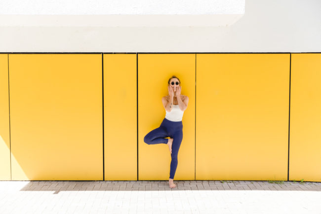 urbanes Yoga Portrait einer Yogalehrerin vor einer gelben Wand in Köln