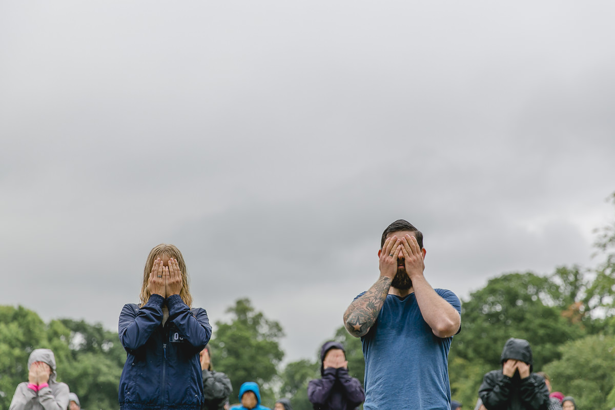 Teilnehmer des Wanderlust Yoga Festivals halten sich die Augen zu