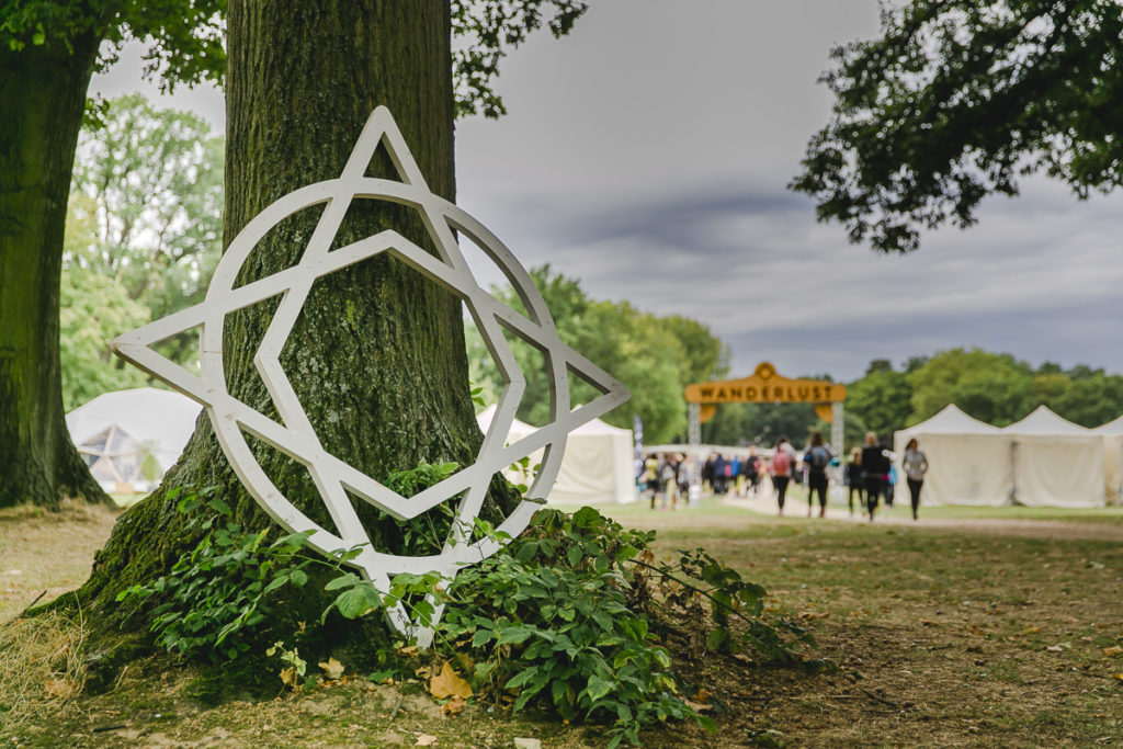 das Wanderlust Festival Symbol vor einem Baum