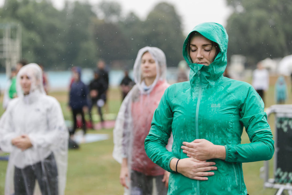 Teilnehmer des Wanderlust Yoga Festivals bei einer Übung im Regen