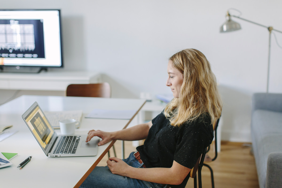 Portrait einer Agentur Mitarbeiterin bei der Arbeit am Laptop