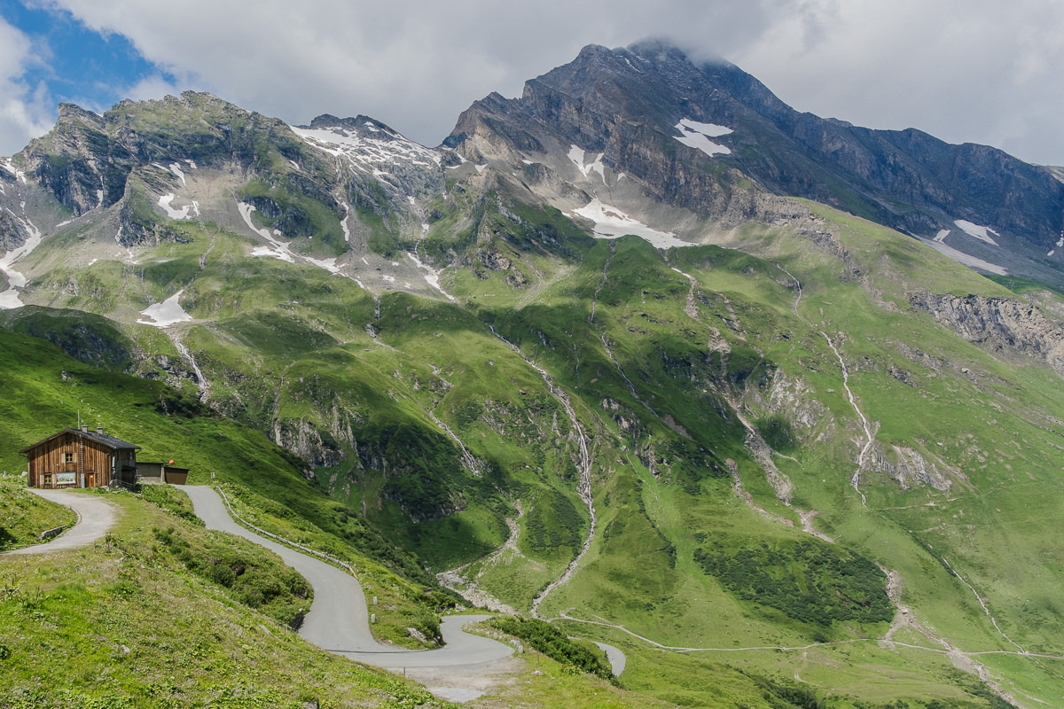 Foto von Bergen mit Wiese und Holzhütte