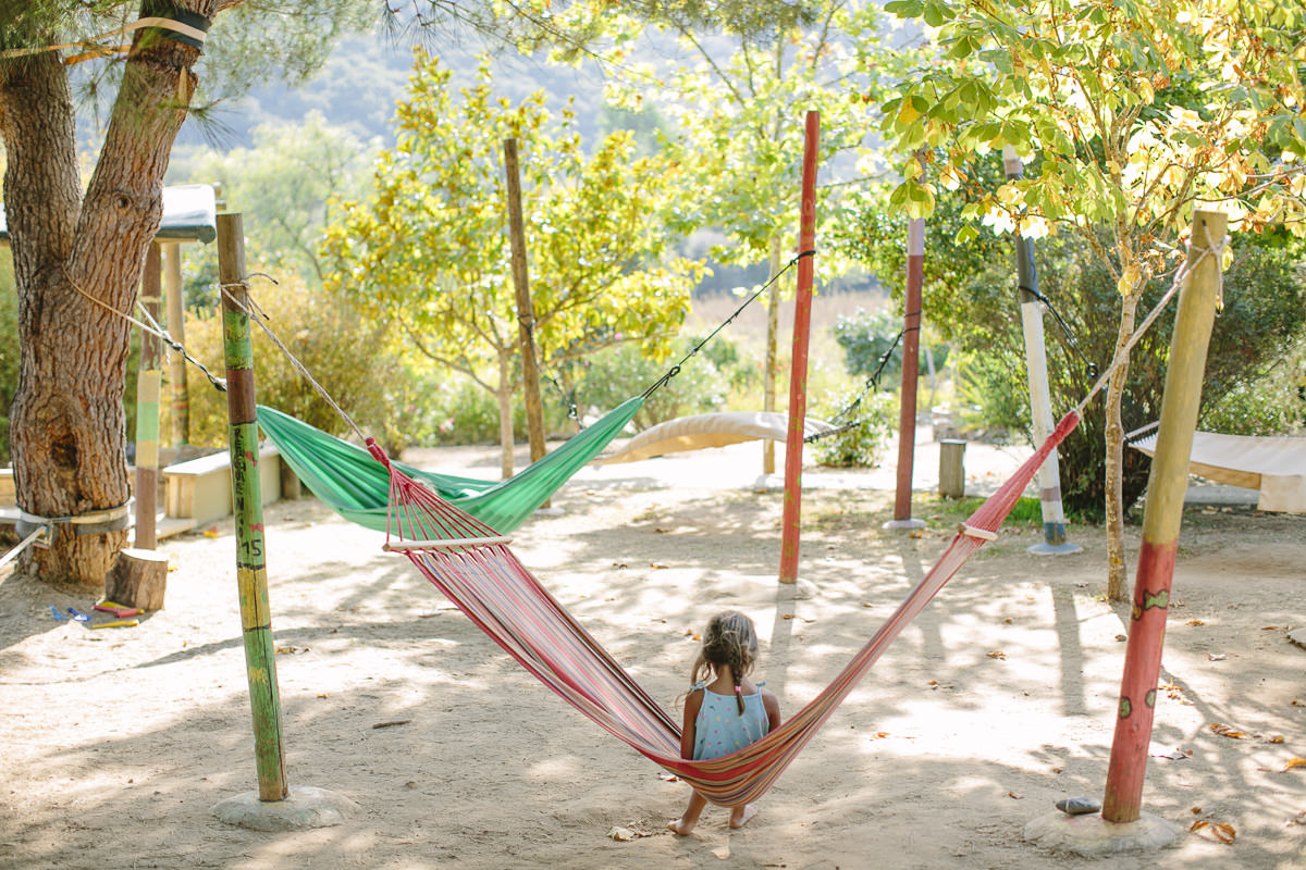 ein Kind sitzt in einer Hängematte in einem Yoga Retreat in Portugal