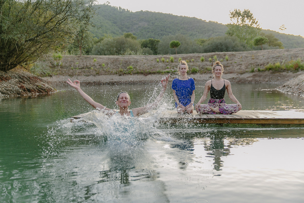 Teilnehmer eines Yoga Retreats bei einer Übung am Wasser