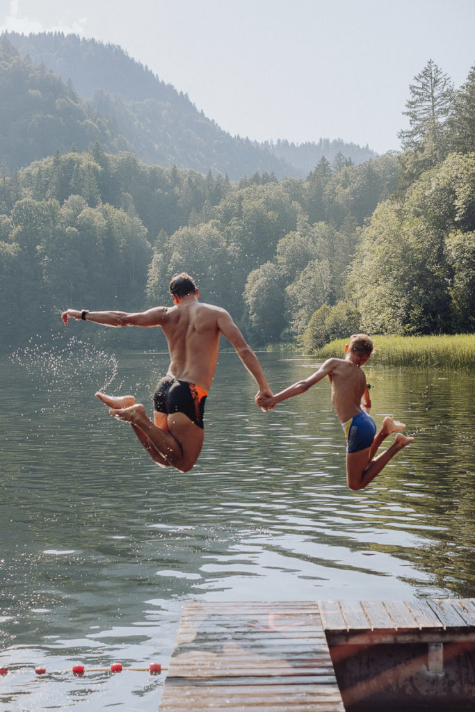 Gäste des 3-Sterne Hotels Naturhof Stillachtal springen in einen See | Foto: Hanna Witte