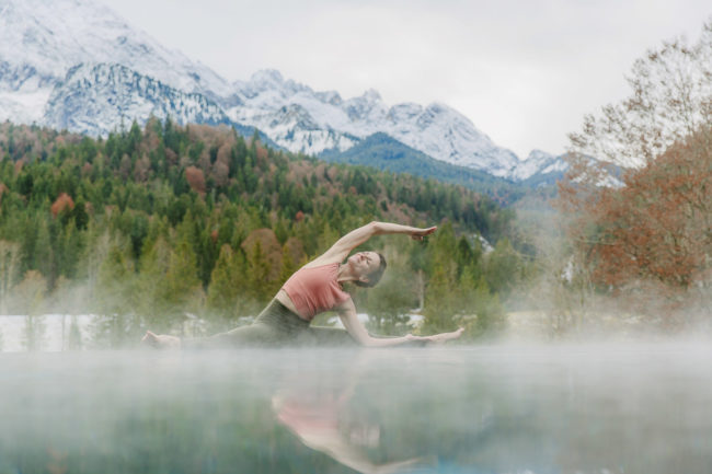 Yoga Foto am Infinity Pool von Schloss Elmau mit Bäumen und Bergen im Hintergrund | Foto: Hanna Witte