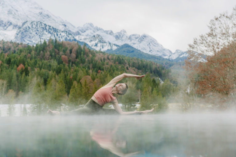 Yoga Foto am Infinity Pool von Schloss Elmau mit Bäumen und Bergen im Hintergrund | Foto: Hanna Witte