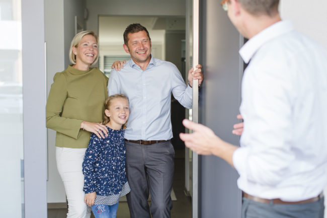 Geschäftsführer Mirko Kleinegreber redet mit einer Familie über eine Haustüre | Corporate Foto: Hanna Witte