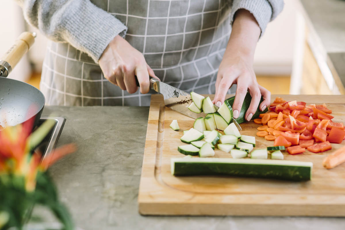 eine Frau schneidet frisches Gemüse als Teil der Social Media Content Fotografie für Eat Happy | Foto: Hanna Witte