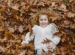 ein Kind liegt zwischen Herbstblättern | Foto: Hanna Witte