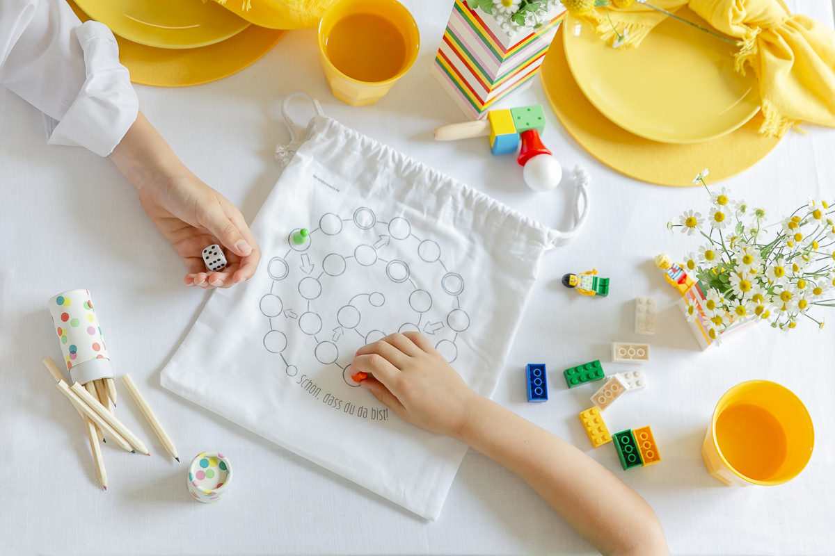 Kinder spielen mit dem Leiterspielaufdruck ihres Gastgeschenkebeutels von Leo Kinderevents | Foto: Hanna Witte