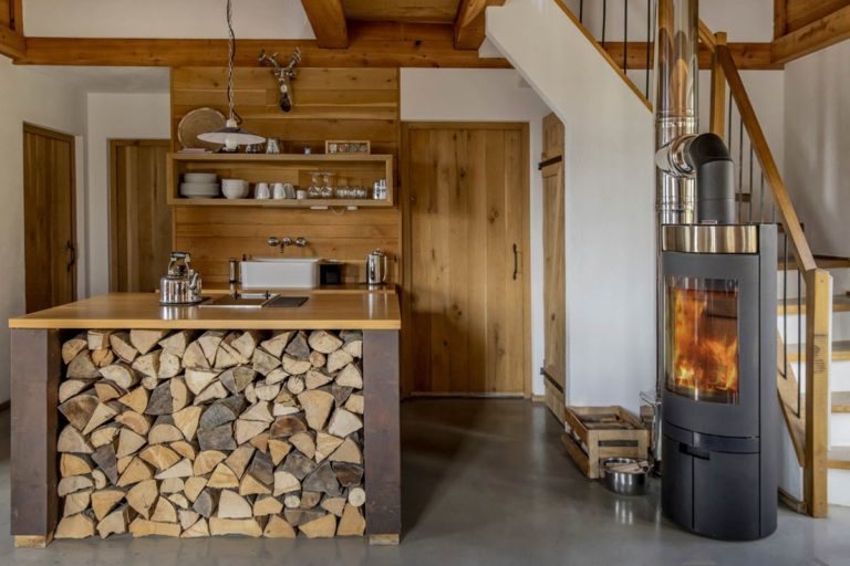 Wohnküche mit Kaminofen in einer Berghütte des Bergdorfs Liebesgrün | Foto: Hanna Witte