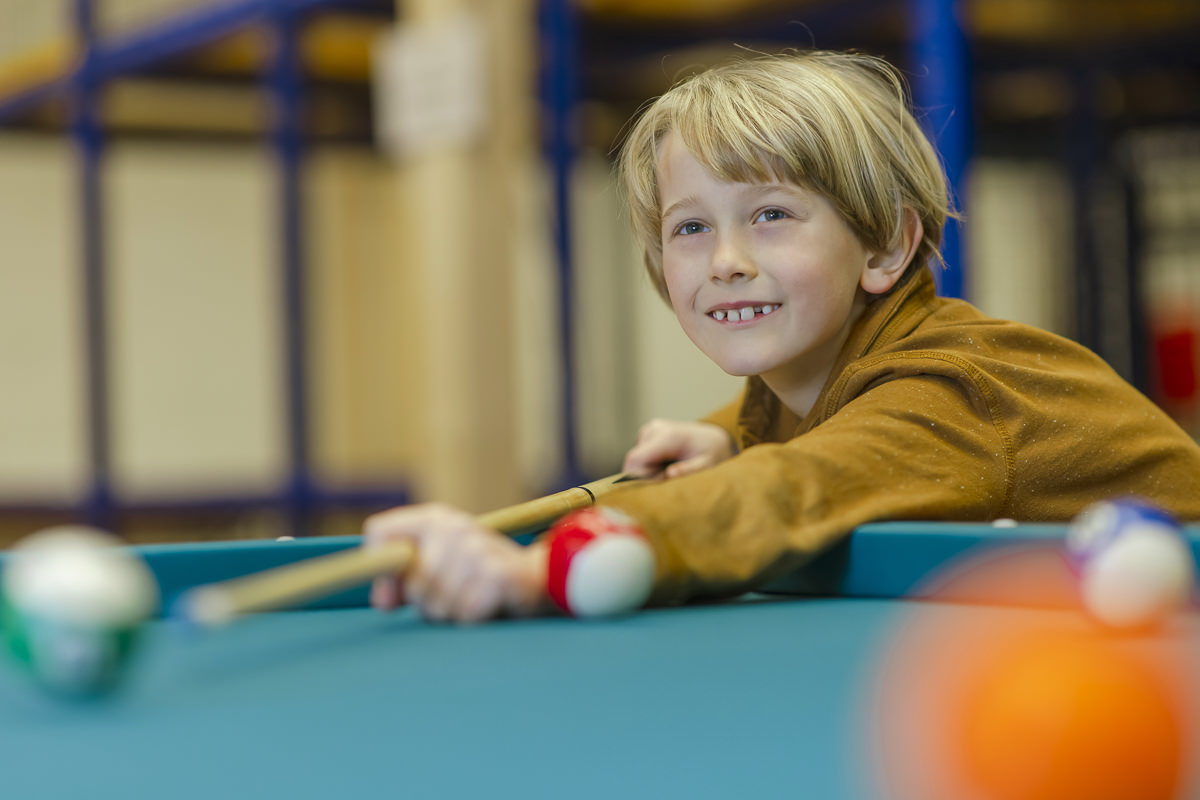 Indoor Spaß beim Familienurlaub in der Nebensaison: Ein Junge spielt Billard | Foto: Hanna Witte