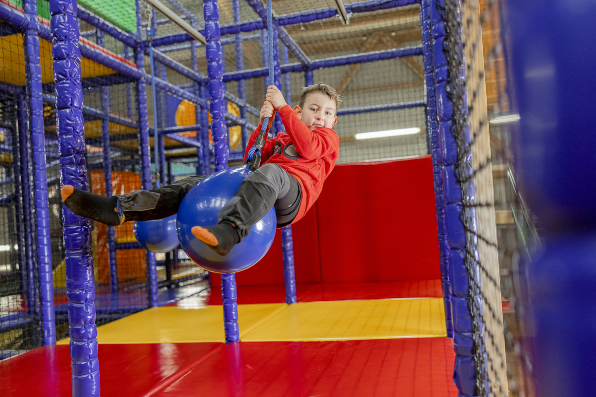 Familienhotel Fotografie Nebensaison: Ein Junge spielt in einer Indoor Spielhalle | Foto: Hanna Witte