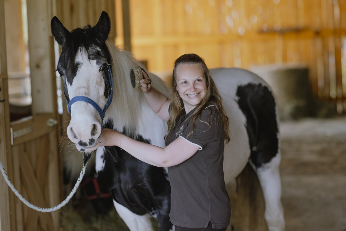 Portraitfoto einer Ferienhof Angestellten bei der Pferdepflege | Foto: Hanna Witte