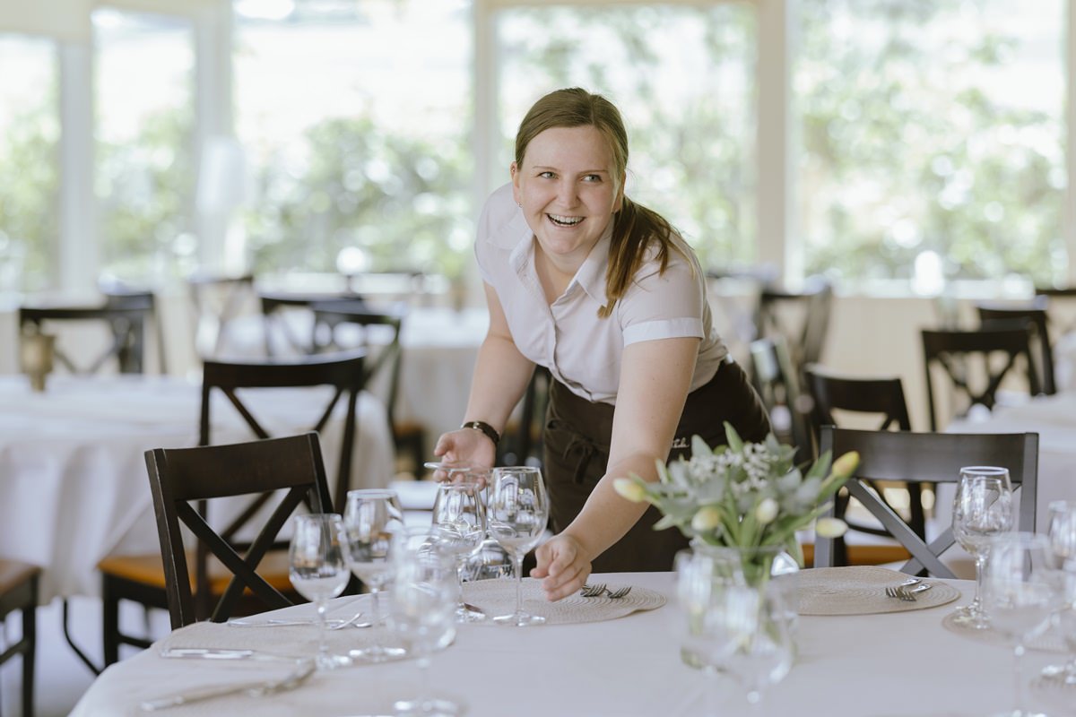 eine Angestellte des Hotels Ferienhof Hardthöhe deckt einen Tisch ein | Foto: Hanna Witte