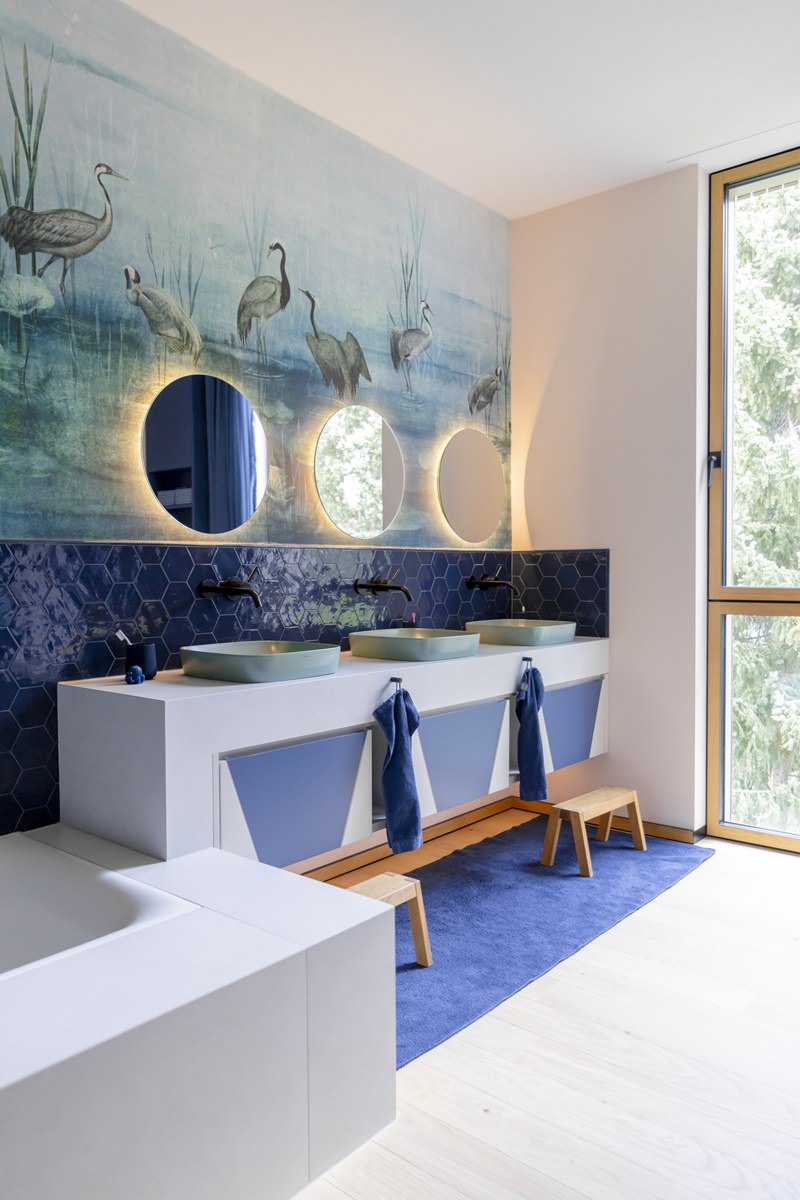 modern ausgestattes Badezimmer in blau und weiß, mit drei Waschbecken, Spiegeln und Tiermuster Tapete | Foto: Hanna Witte