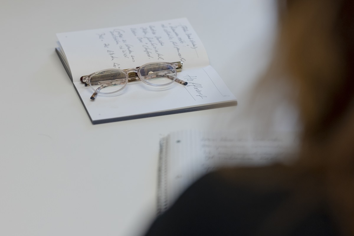 zusammengeklappte Brille, die auf einem aufgeschlagenen Notizbuch liegt | Foto: Hanna Witte