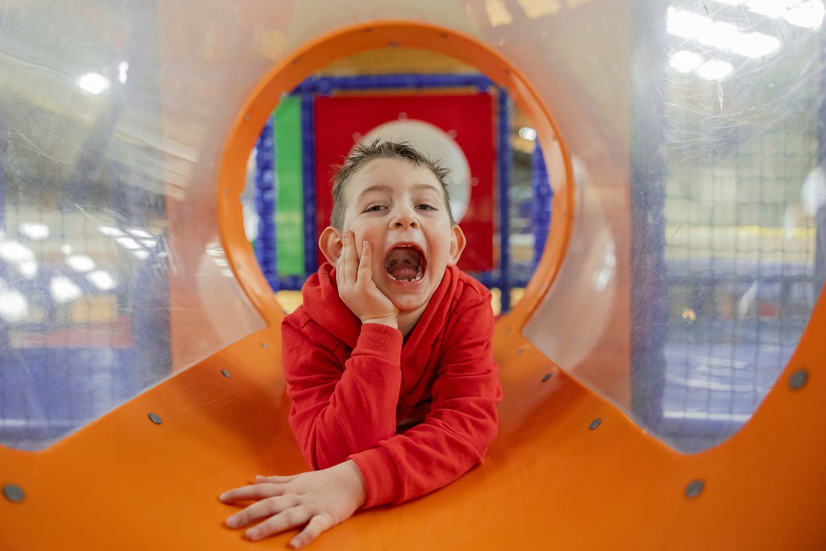 ein Junge spielt in der Röhre eines Indoor Spielplatzes, der zu einem Familienhotel gehört | Foto: Hanna Witte