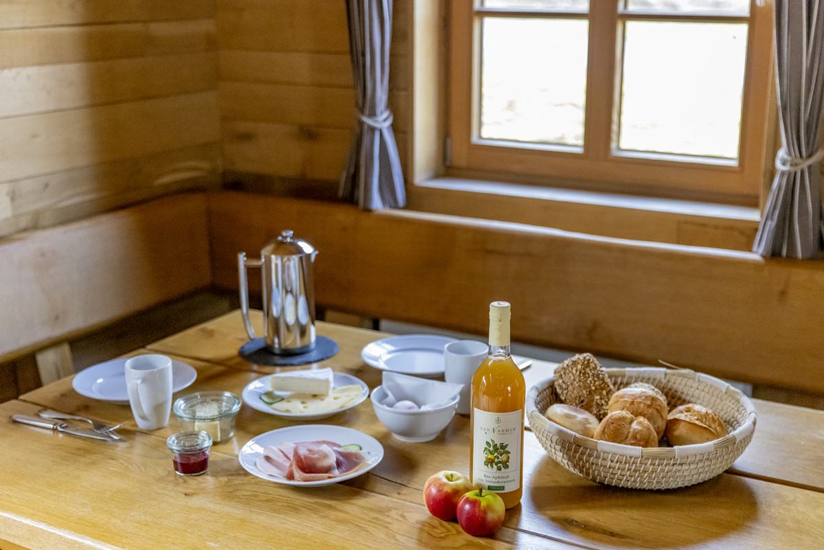 Sitzecke mit gedecktem Frühstückstisch in einer rustikalen Berghütte | Foto: Hanna Witte