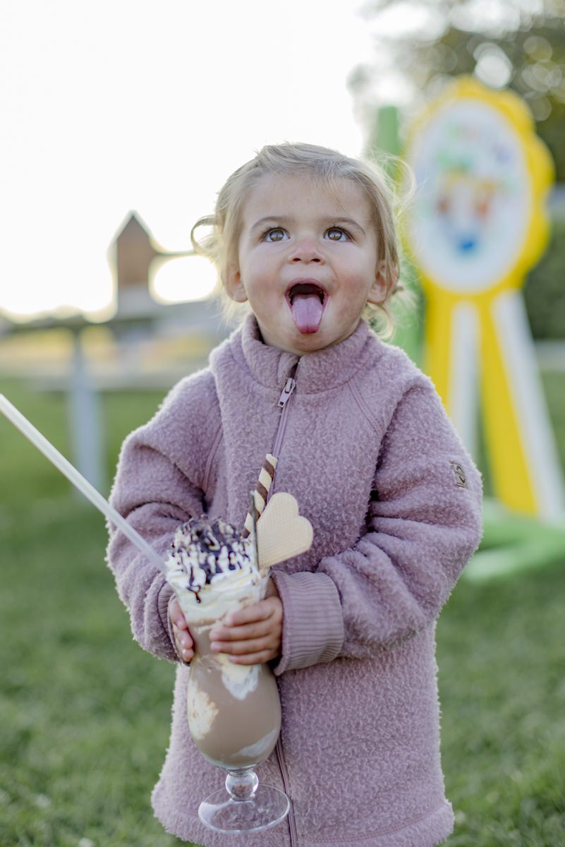 ein Kleinkind hält ein großes Glas mit Eisschokolade in der Hand | Foto: Hanna Witte