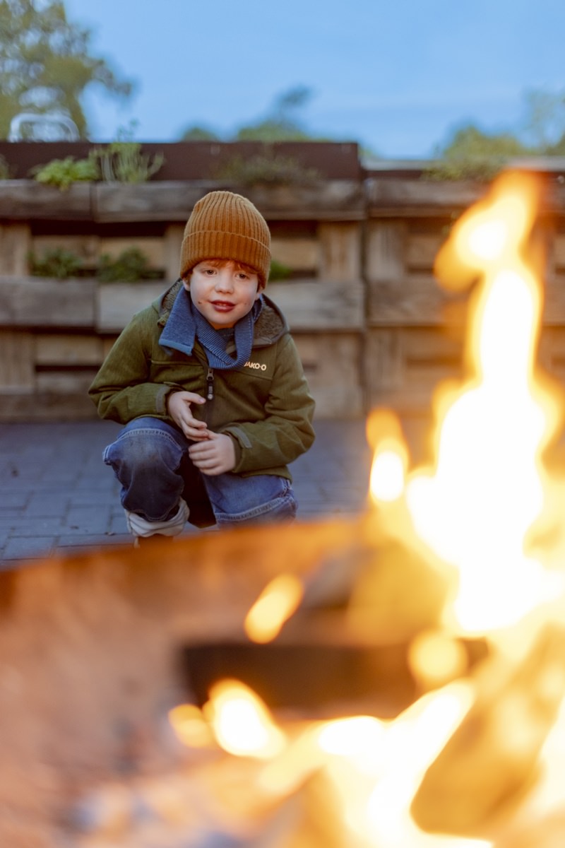 ein kleiner Junge sitzt vor einem Lagerfeuer | Foto: Hanna Witte