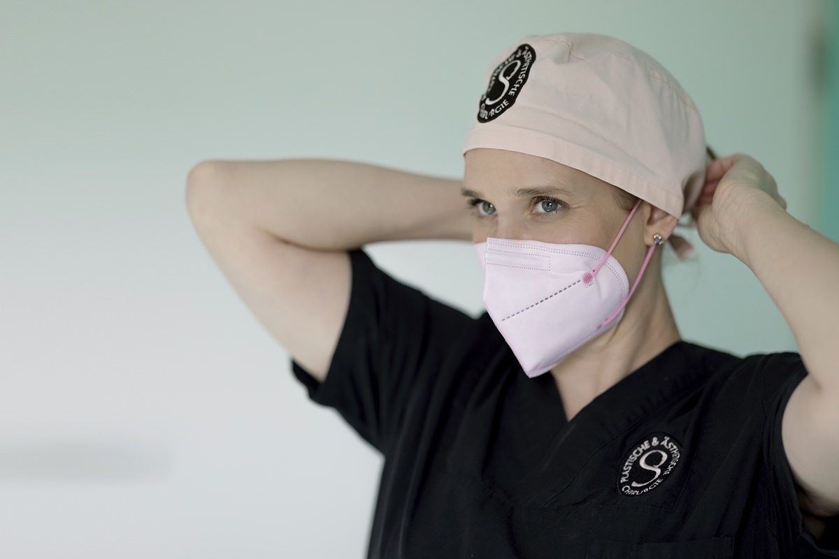 die plastische Chirurgin Dr. Pirkko Schuppan bindet ihre OP-Haube zu | Foto: Hanna Witte
