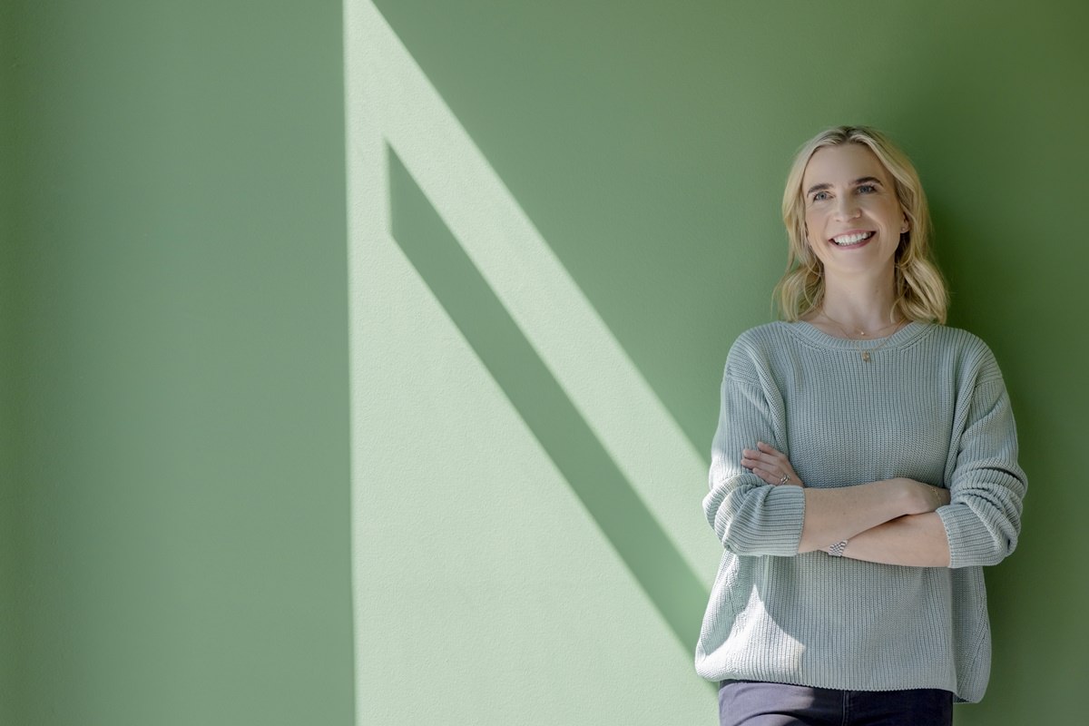 BabyOne Geschäftsführerin Dr. Anna Weber steht fürs Portraitfoto vor einer grünen Wand | Foto: Hanna Witte