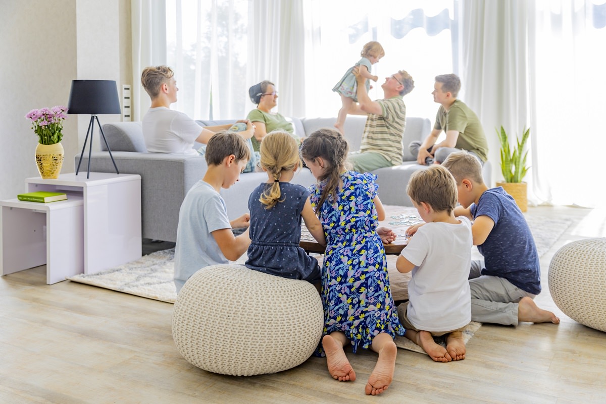 Eltern sitzen mit ihren acht Kindern in einem neu eingerichteten Wohnzimmer | Foto: Hanna Witte