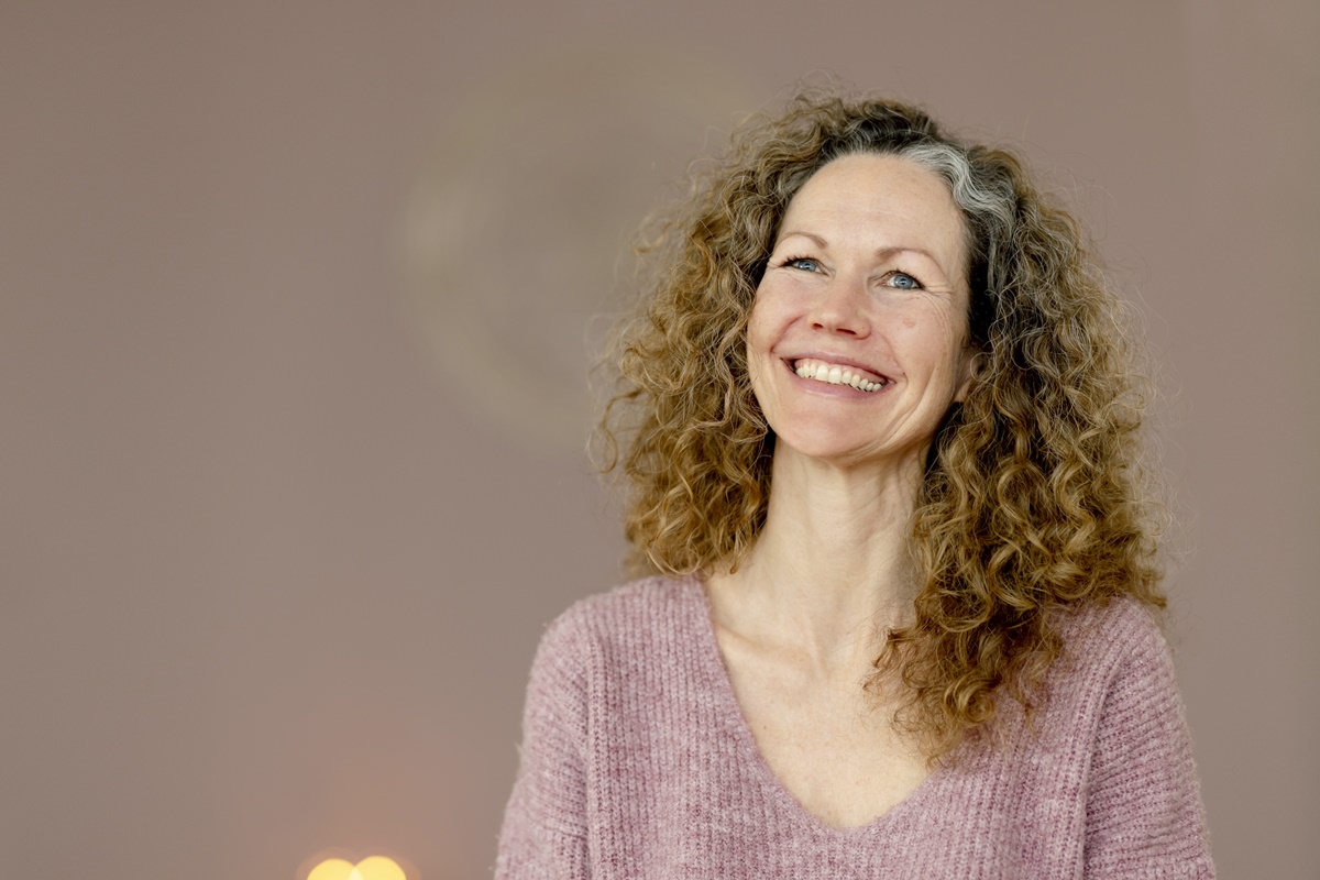 sympathisches Yoga Portrait von Lehrerin Andrea Zettl vor einer hellbraunen Wand | Foto: Hanna Witte