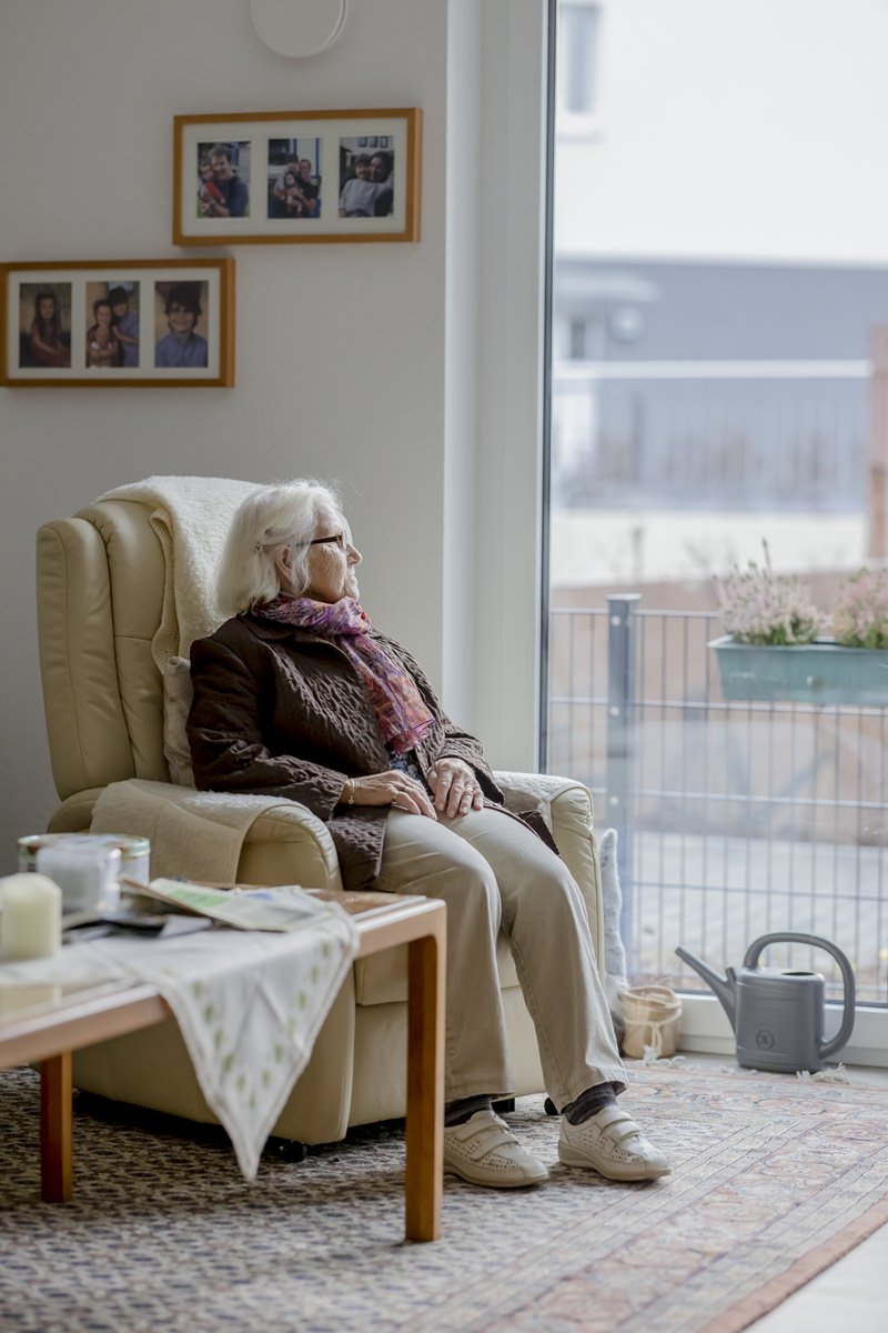 eine Demenz-WG Bewohnerin sitzt in ihrem Sessel und schaut aus dem Fenster | Foto: Hanna Witte