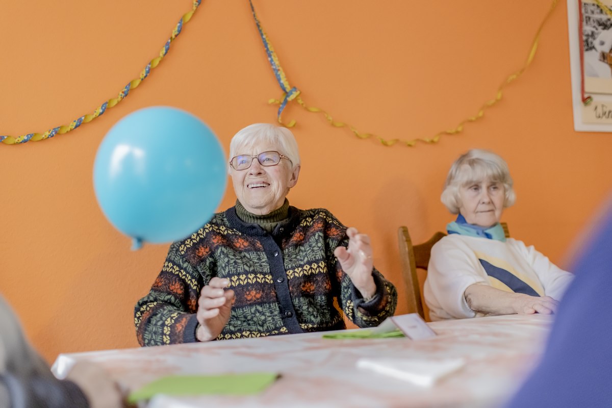 eine Demenz-WG Bewohnerin freut sich über einen blauen Luftballon | Foto: Hanna Witte