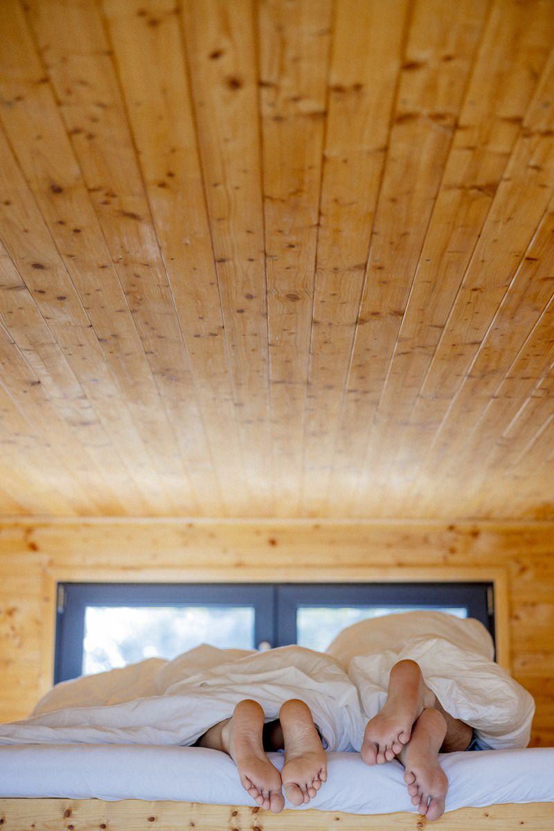 die Füße von schlafenden Tiny House Gästen schauen unter der Decke hervor | Foto: Hanna Witte
