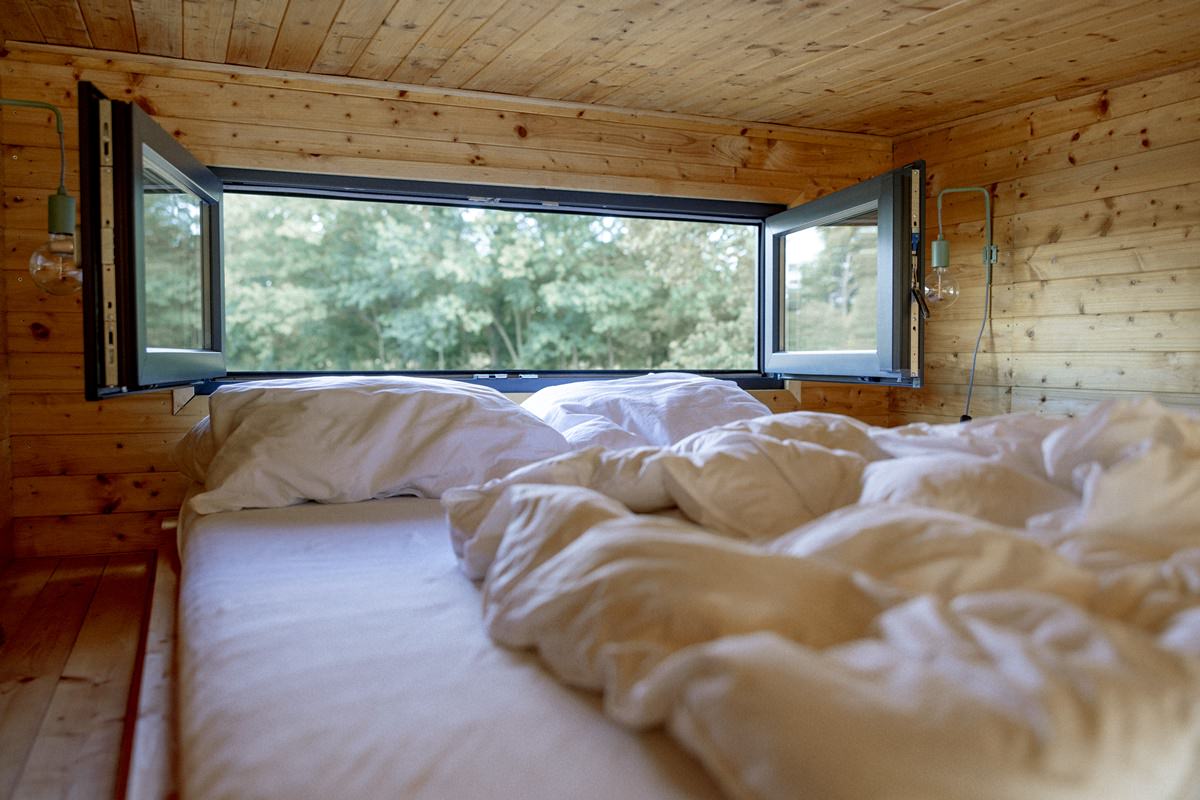 Schlafbereich mit geöffneten Fenstern im Kuckuck Tiny House | Foto: Hanna Witte