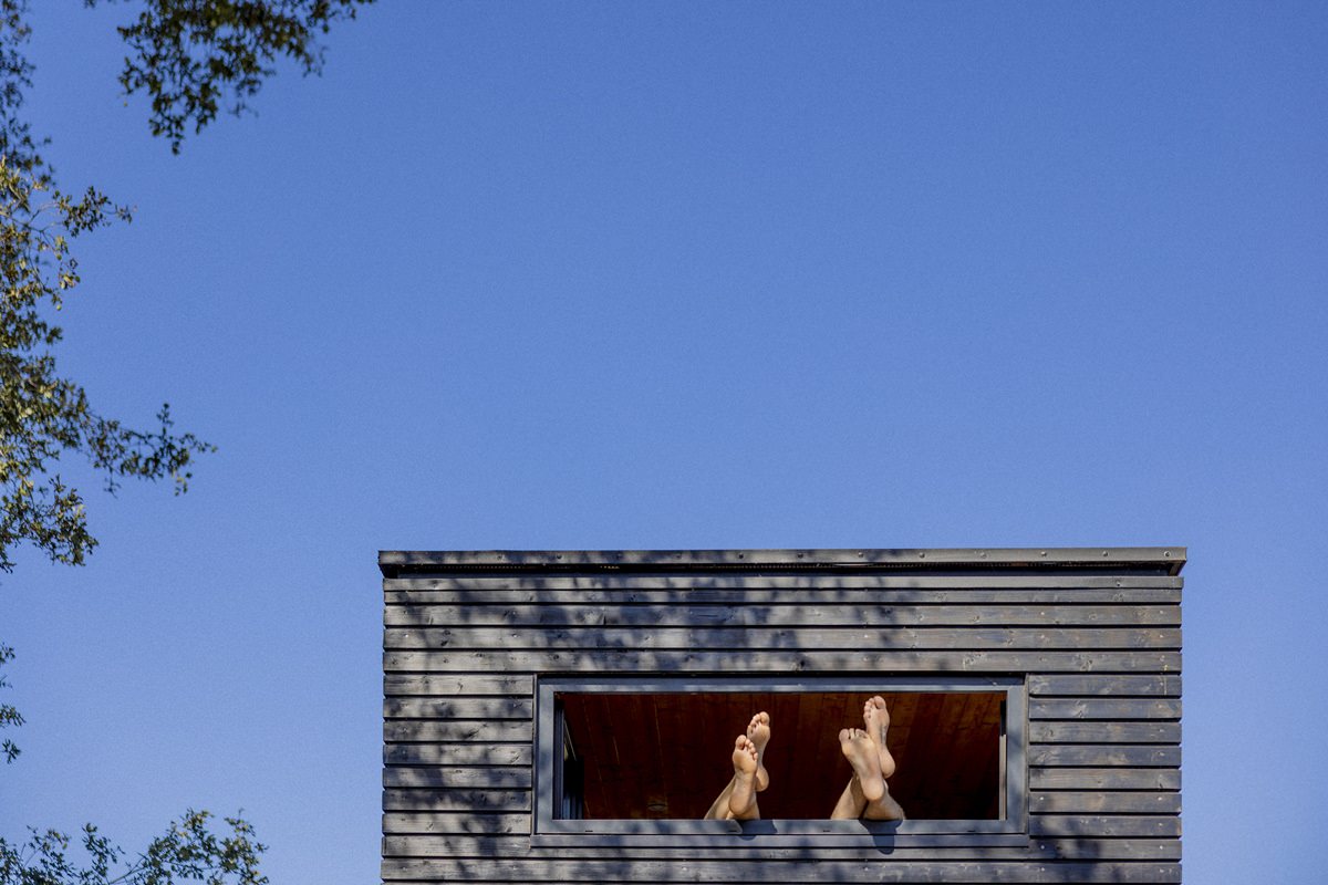 Gäste des Kuckuck Tiny House halten ihre Füße aus dem Fenster | Foto: Hanna Witte