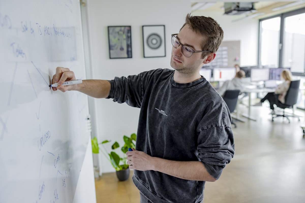 ein taod Mitarbeiter skizziert Arbeitsabläufe an einem Whiteboard | Foto: Hanna Witte