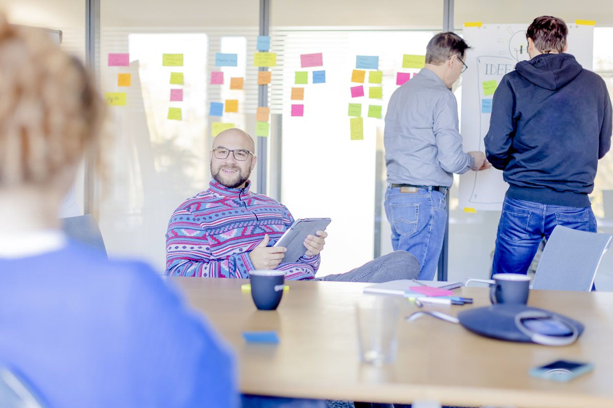 Mitarbeiter von grandcentrix arbeiten im Konferenzraum gemeinsam an einem Projekt | Foto: Hanna Witte