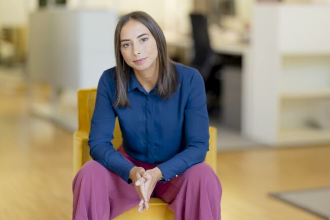 eine junge Mitarbeiterin des Innenarchitekturbüros brandherm + krumrey sitzt für das Portraitfoto auf einem Stuhl | Foto: Hanna Witte