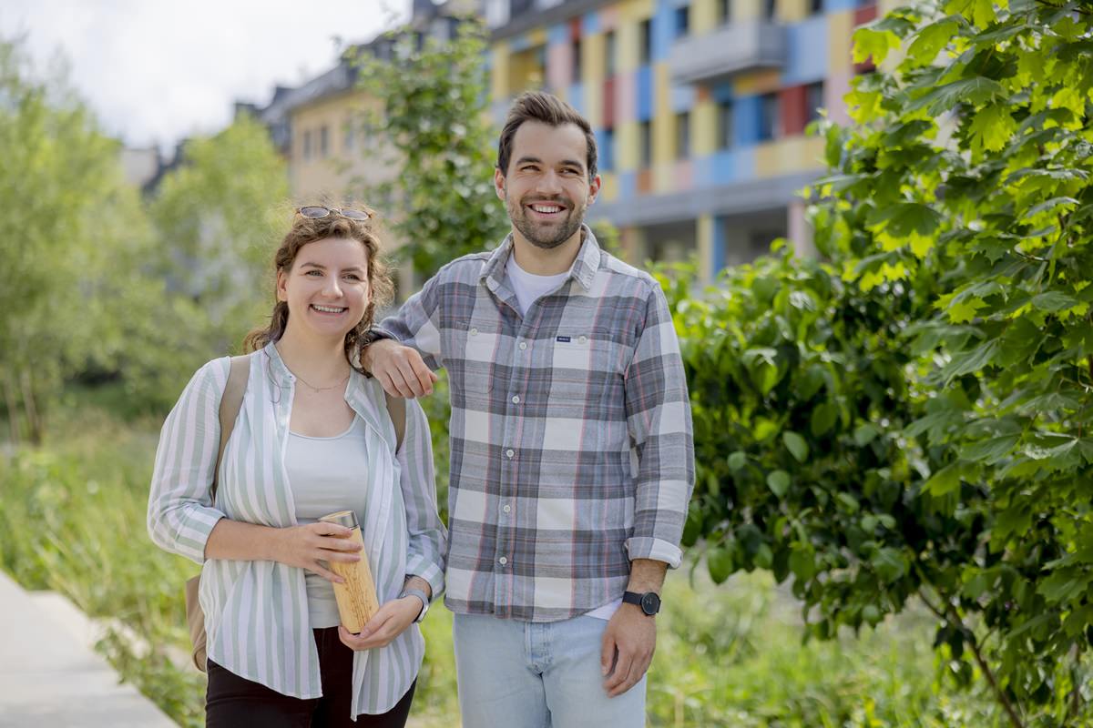 zwei Studenten auf einem begrünten Weg auf dem Gelände der Uni Siegen | Foto: Hanna Witte