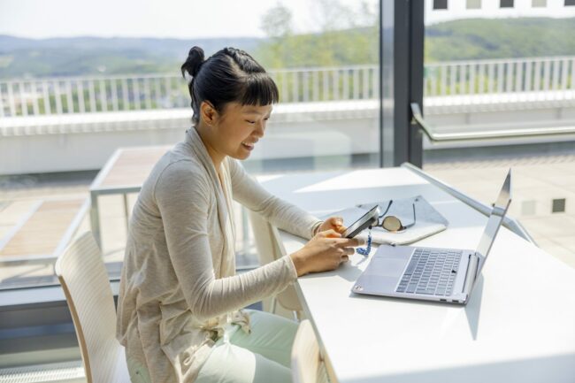 eine Studentin der Uni Siegen schaut in der Mensa auf ihr Handy | Foto: Hanna Witte