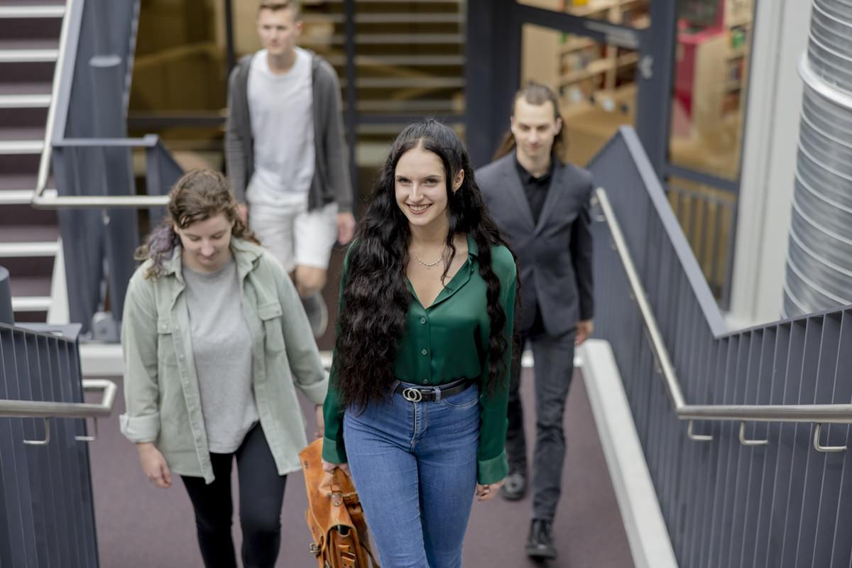 Studenten der Uni Siegen lufen eine Treppe im Inneren des Campus hinauf | Foto: Hanna Witte