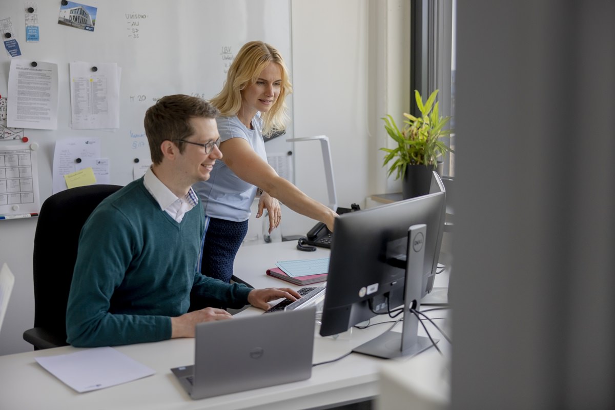 zwei Mitarbeiter der Pressestelle der Uni Siegen arbeiten gemeinsam am Computer | Foto: Hanna Witte